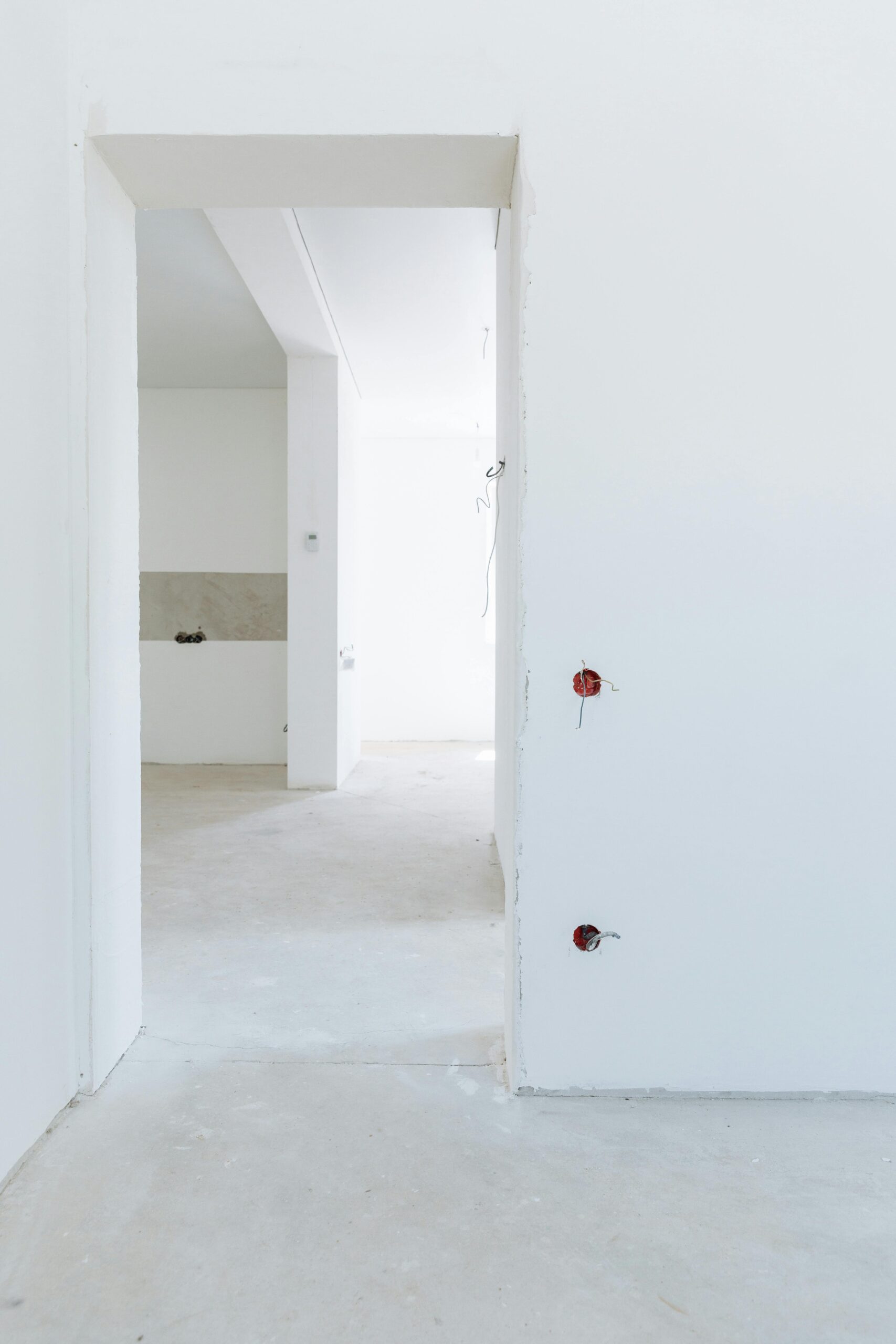 Textured white wall with abstract shadows, creating a serene pattern.